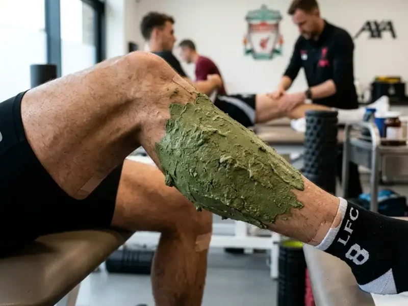 Cataplasme d'argile verte sur le mollet d'un footballeur pour la récupération musculaire après le sport.