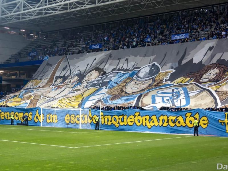Tifo géant déployé par des supporters dans un stade de football bondé.