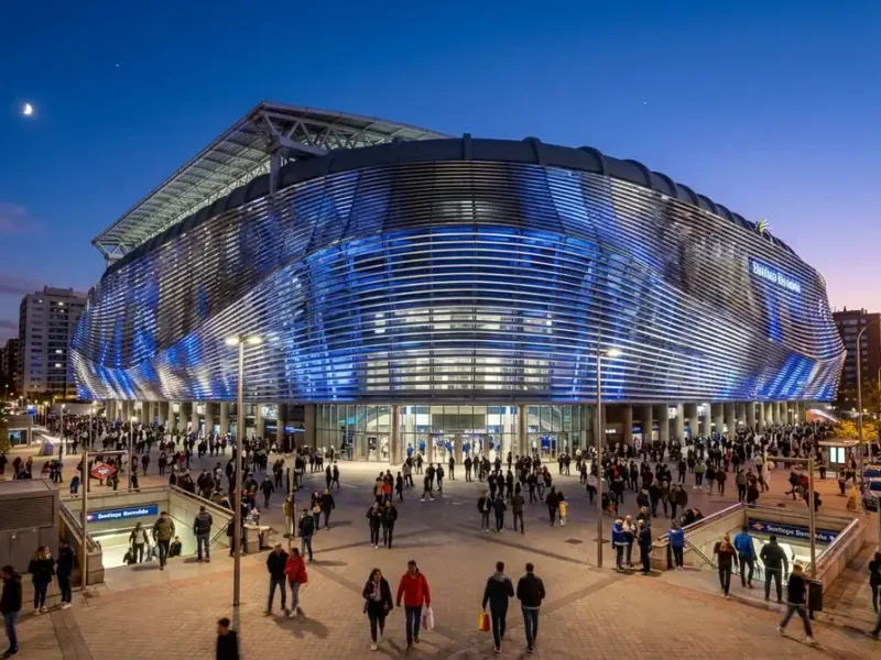 Façade futuriste du stade Santiago Bernabéu illuminée de nuit, symbole du Real Madrid et de son mercato 2026.